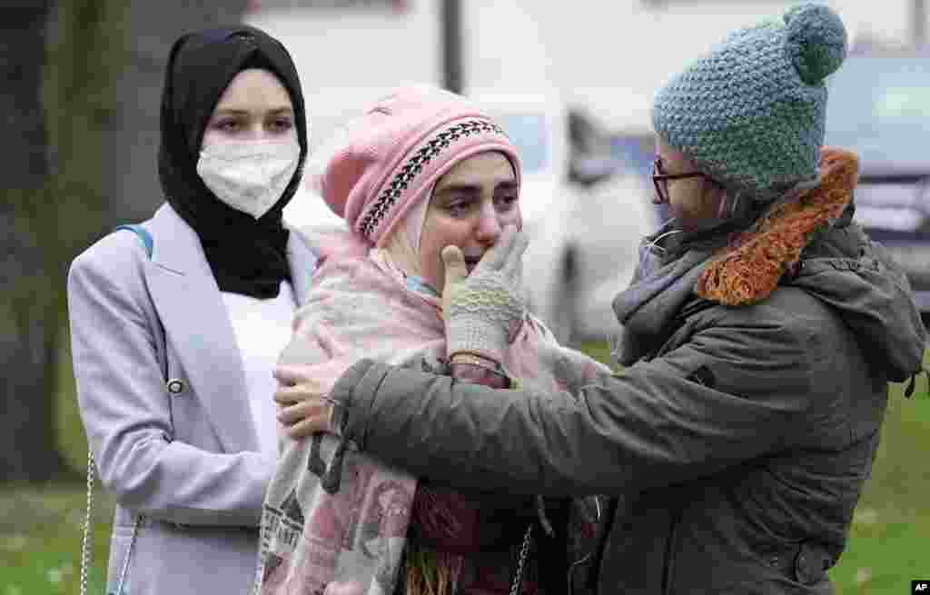 Syrian women Yasemine, center, who lost her father and brother in Syria, reacts after the verdict in front of the court in Koblenz, Germany. A German court has convicted Anwar Raslan, a former Syrian secret police officer, of crimes against humanity for overseeing the abuse of detainees at a jail near Damascus a decade ago.