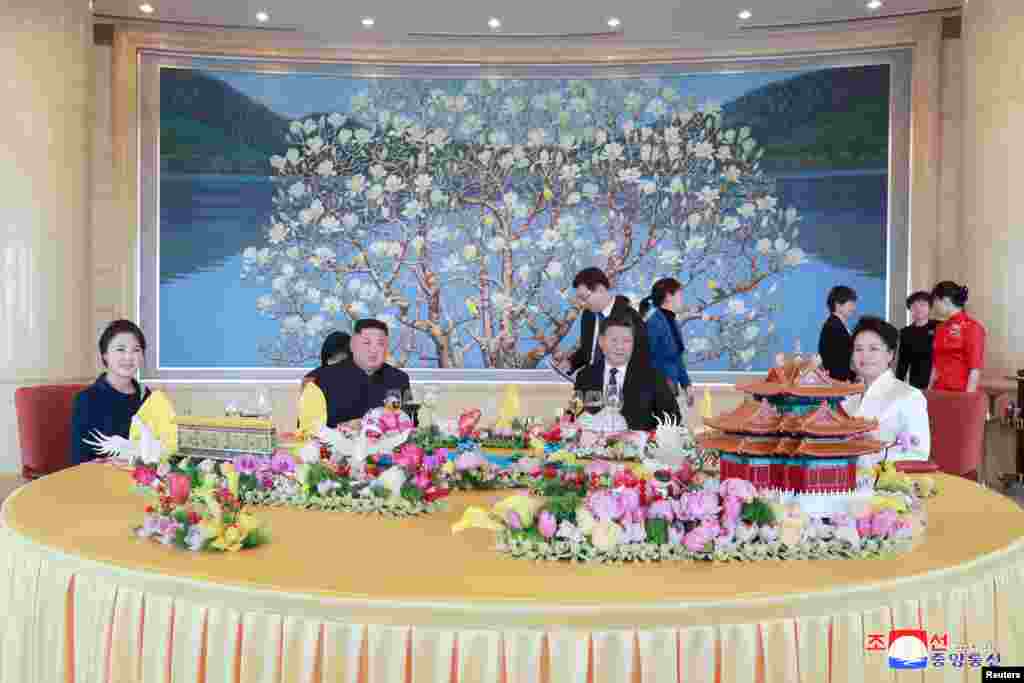 North Korean leader Kim Jong Un and wife Ri Sol Ju meet with Chinese President Xi Jinping and his wife Peng Liyuan in Beijing, China, in this photo released by North Korea's Korean Central News Agency (KCNA).