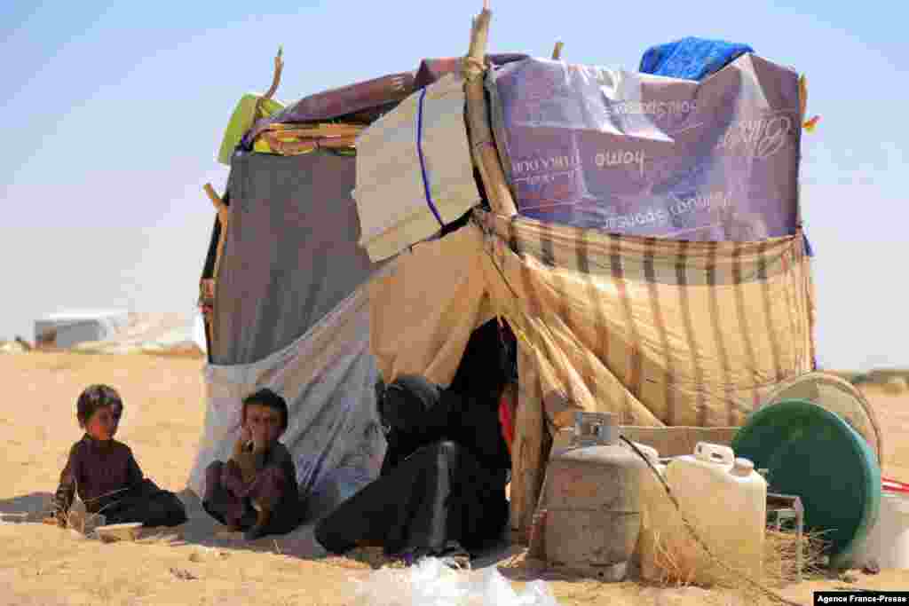 A woman sits with children at a camp for internally displaced people on the outskirts of Yemen's northeastern city of Marib, the final northern stronghold of pro-government forces, Nov. 3, 2021.