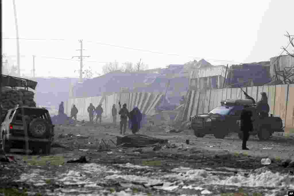 Afghan security forces gather the next day at the site of an attack in Kabul. A Taliban suicide bomber detonated an explosive-laden vehicle in the capital on Jan. 14, according to officials.