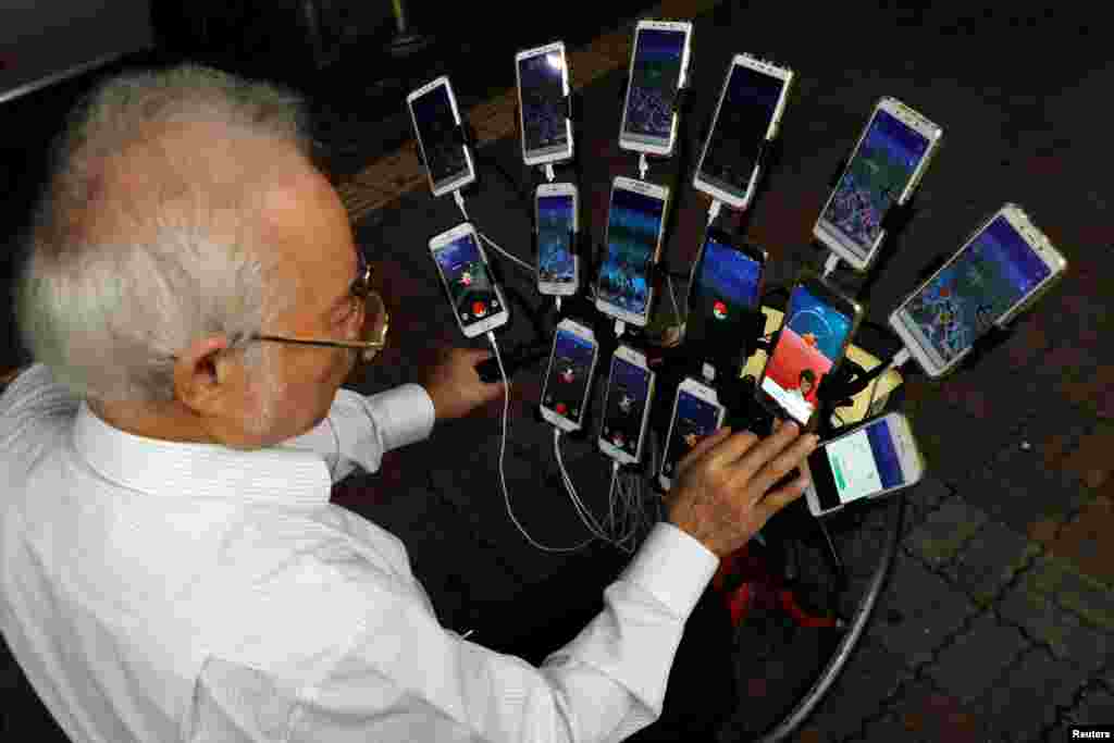 Taiwanese Chen San-yuan, 70, known as "Pokemon grandpa", plays the mobile game "Pokemon Go" by Nintendo, near his home with 15 mobile phones, in New Taipei City, Taiwan, Nov. 12, 2018.
