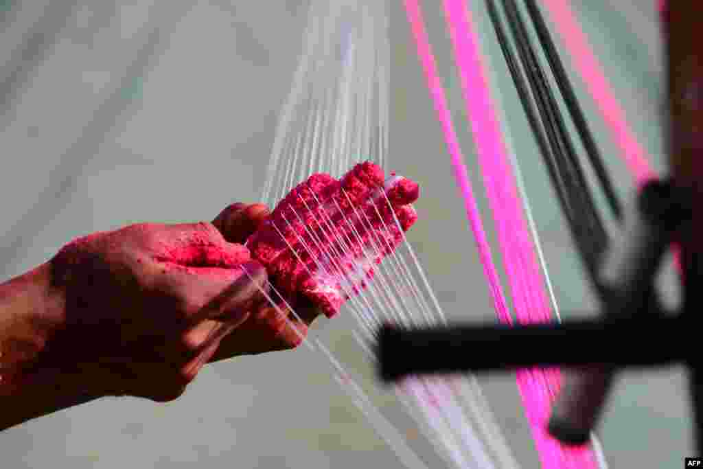 A worker prepares strings coated with powdered glass used for flying kites ahead of 'Uttarayan' festival in Ahmedabad, India.