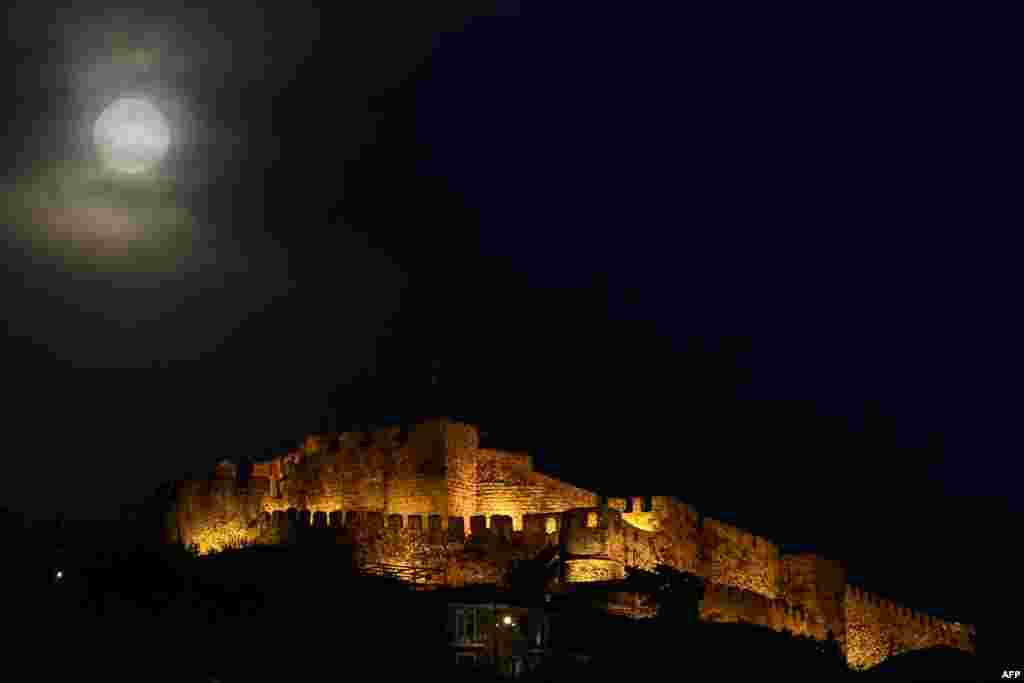 A full moon rises next to the ancient castle of Mithymna Molyvos on the Greek island of Lesbos on March 20, 2019.