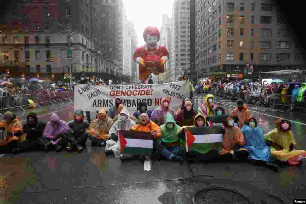 La policía de Nueva York dijo que arrestó a 21 personas después de que los manifestantes se sentaran en la ruta del desfile con banderas y una pancarta que decía "No celebren el genocidio".