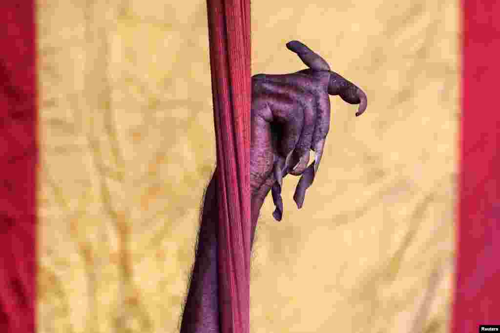 The hand of a Sadhu, or Hindu holy man, who has not moved his arm and cut his fingernails for 10 years, is raised inside his camp during "Kumbh Mela," or the Pitcher Festival, in Prayagraj, previously known as Allahabad, India.