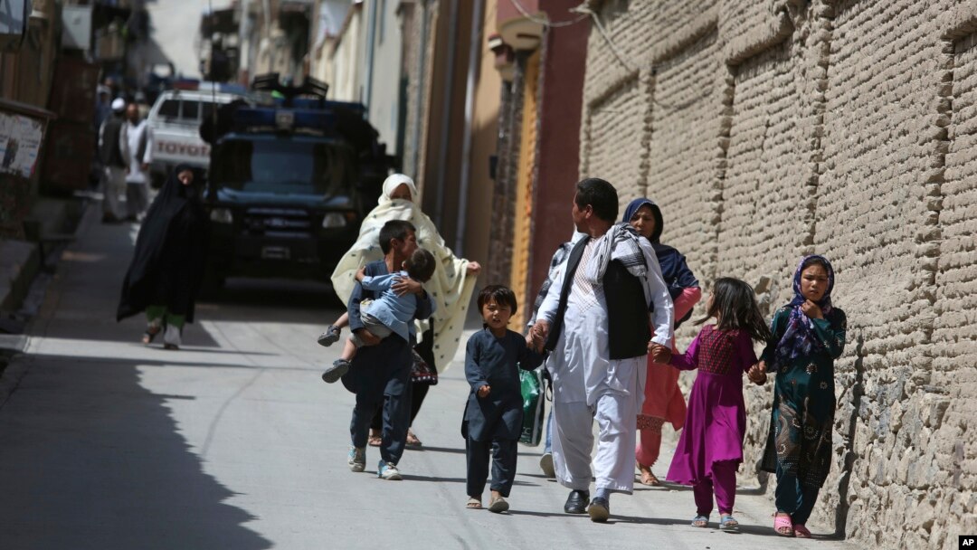 Families leaves their homes after a rocket strike in the western part of Kabul, Afghanistan, July 24, 2018. 