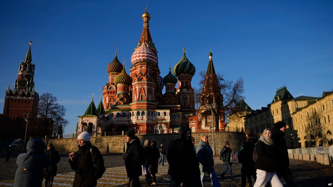 FILE - People walk on the Red Square next to St. Basil's Cathedral and the Spasskaya tower of the Kremlin on a sunny day in Moscow, Nov. 26, 2024.