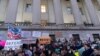 People listen to speakers during a rally against Elon Musk outside the U.S. Treasury Department in Washington, Feb. 4, 2025. 