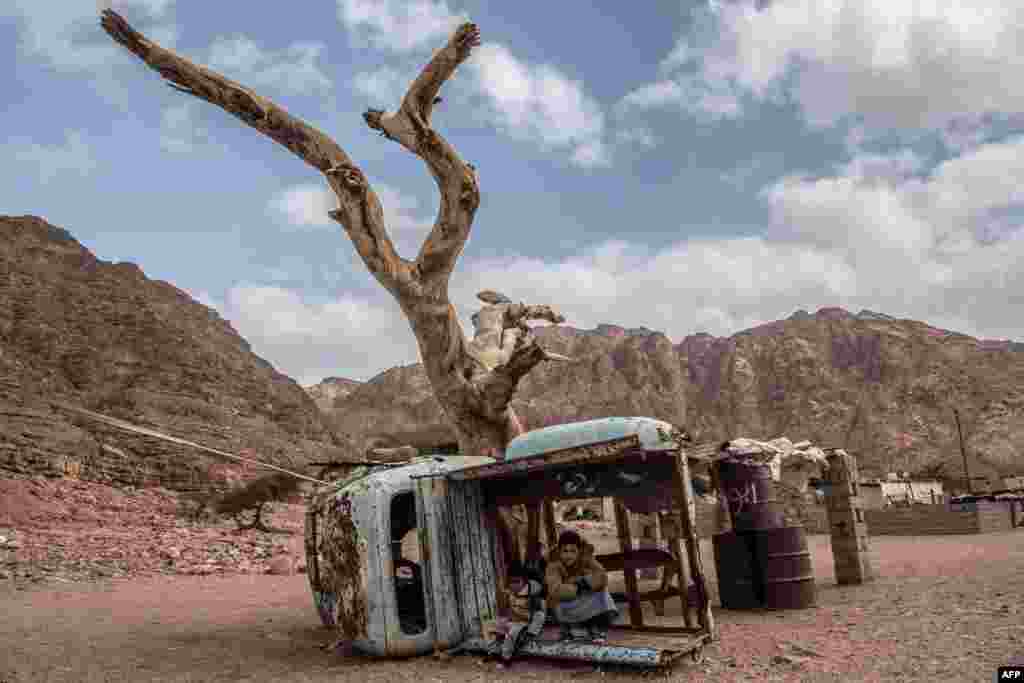 Egyptian Bedouin children sit in a rusted shell of a truck in the village of al-Hamada in Wadi el-Sahu in South Sinai governorate.
