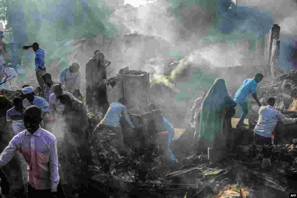 People try to recover items from the remains after a fire broke overnight in Mogadishu's biggest market, the Bakara Market, Somalia.