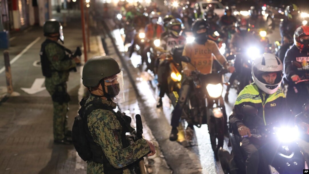 Police officers inspect motorcycle riders at a checkpoint during a stricter lockdown as a precaution against the spread of the coronavirus at the outskirts of Marikina City, Philippines on Friday, August 6, 2021. Thousands of people jammed…
