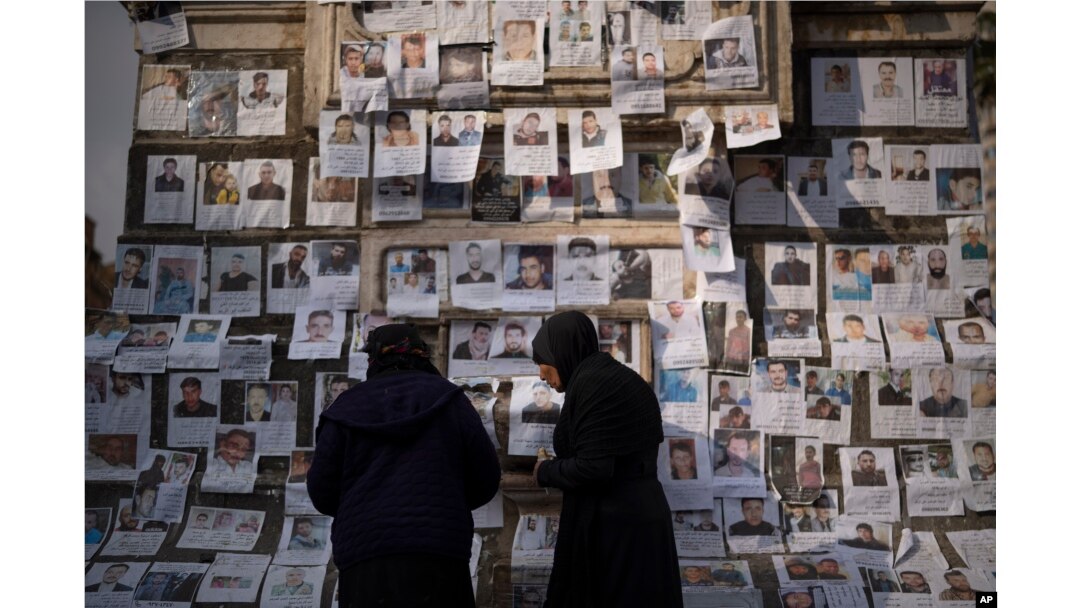 Women look at photos of people reported to be missing by members of ousted Syrian President Bashar al-Assad's army in the Marjeh square in Damascus, Dec. 22, 2024.