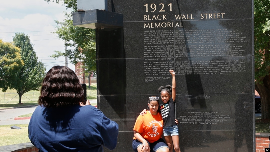 Katrina Cotton, centro de Houston, posa para una foto con su hija, Kennedy Cotton en el memorial de Black Wall Street en Tulsa, Oklahoma.