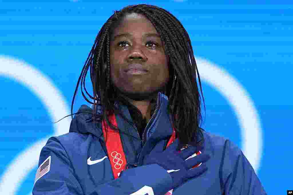 Gold Medalist Erin Jackson of the United States stands for her national anthem during the medal ceremony for the speedskating women's 500-meter race at the 2022 Winter Olympics in Beijing.