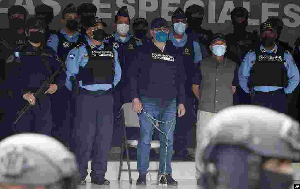 Former Honduran President Juan Orlando Hernandez, center in chains, is shown to the press at Police Headquarters in Tegucigalpa, Honduras, Feb. 15, 2022. Police arrested Hernandez at his home following a request by the U.S. government for his extradition on drug trafficking and weapons charges.