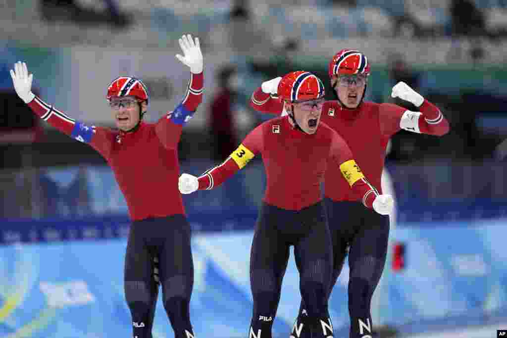Team Norway's Peder Kongshaug, center, Sverre Lunde Pedersen, left, and Hallgeir Engebraaten react after winning the gold medal in the speedskating men's team pursuit finals at the 2022 Winter Olympics in Beijing.