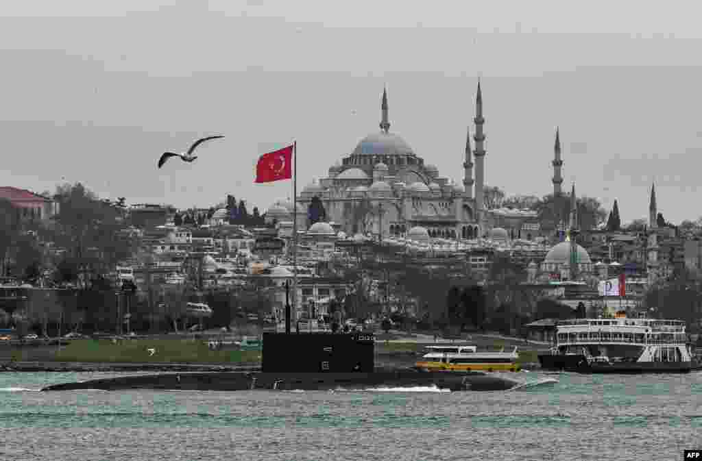 Russian Navy's diesel-electric Kilo class submarine Rostov-on-Don sails through the Bosphorus Strait on the way to the Black Sea past the city Istanbul, Turkey, as Suleymaniye mosque is seen in the backround, Feb. 13, 2022.