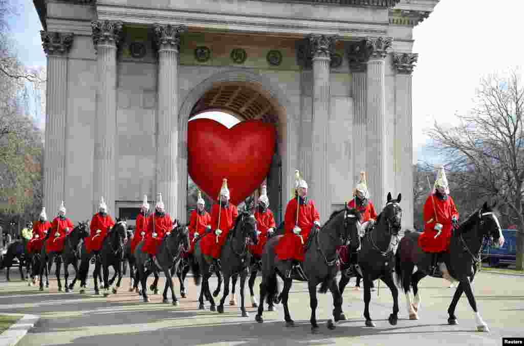 Members of the Household Cavalry walk past Wellington Arch and a large inflatable heart, on Valentine's Day in London.