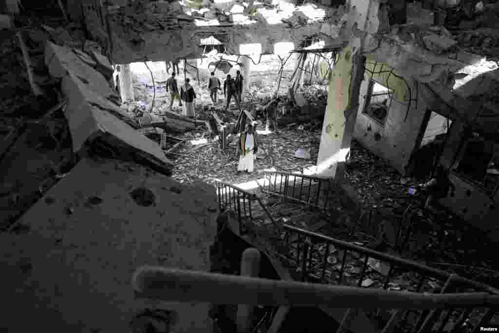 Security guards and journalists inspect the site of Saudi-led airstrike on a telecommunication station in Sana'a, Yemen.