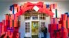 A Marine White House Military social aide holds the door to the East Wing entrance of the White House during a press preview of the White House holiday decorations, Nov. 29, 2021.