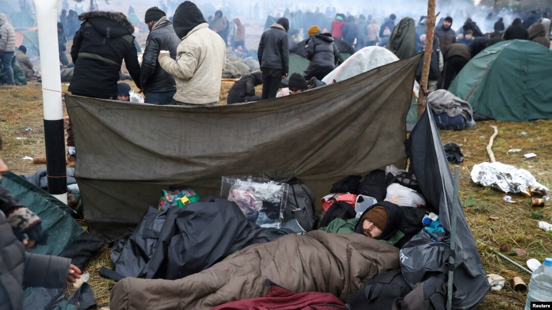A migrant man sleeps in a camp near Bruzgi-Kuznica checkpoint on the Belarusian-Polish border in the Grodno region, Belarus, Nov. 18, 2021.