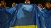 People wave a Ukrainian flag in support of the country in Kramatorsk, Ukraine, Feb. 23, 2022. U.S. President Joe Biden announced the U.S. was ordering heavy financial sanctions against Russia, for what he called the "beginning of a Russian invasion of Ukraine."