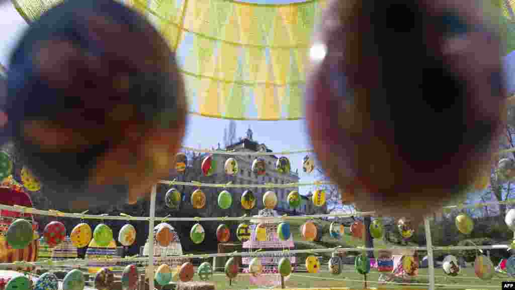 Colorful hand-painted eggs arranged within larger egg-shaped structures are on display in the park of the Baroque Castle as part of the Easter decorations in Ludwigsburg, southern Germany.