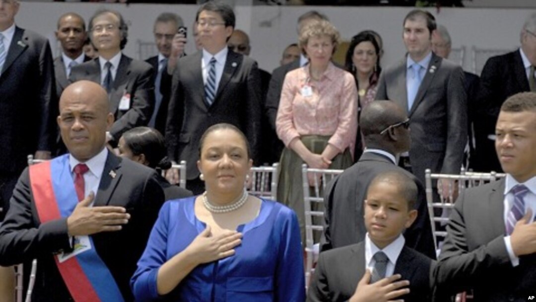 Haiti's President Michel Martelly and family stand for the national anthem during the inauguration ceremony in Port-au-Prince, May 14, 2011