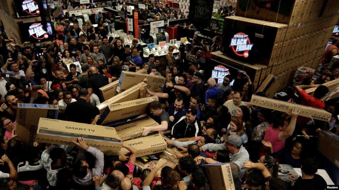 Shoppers reach out for television sets as they compete to purchase retail items on Black Friday at a...