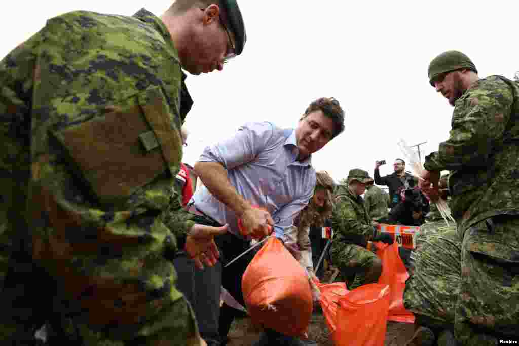 Canada's Prime Minister Justin Trudeau helps prepare sandbags near a flooded area in Gatineau, Quebec, April 24, 2019.