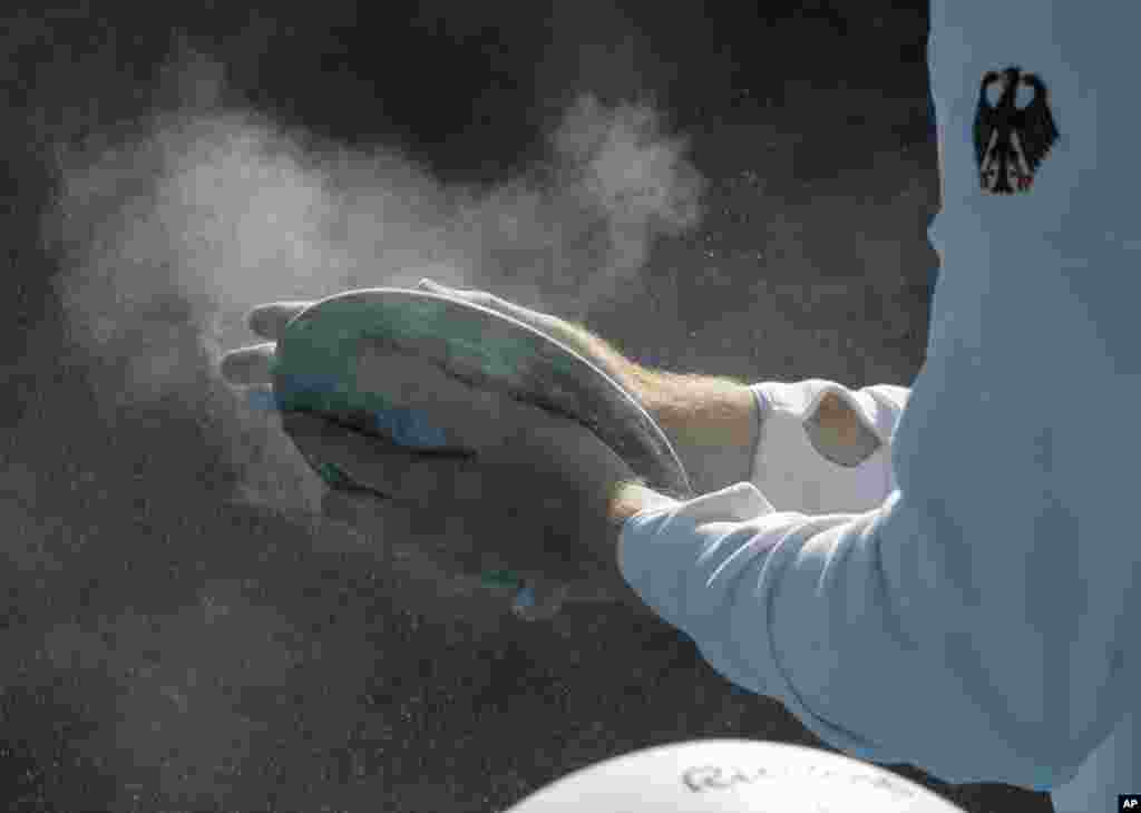 Germany's Christoph Harting prepares a discus with chalk prior to the men's discus throw final during the athletics competitions of the 2016 Summer Olympics at the Olympic stadium in Rio de Janeiro, Brazil, Aug. 13, 2016.