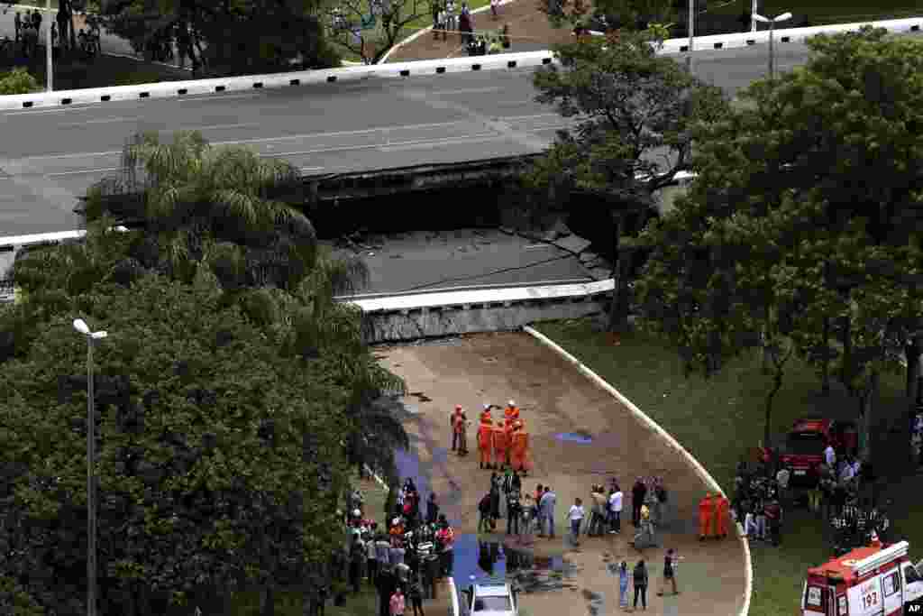 Emergency personnel work on an overpass that collapsed, destroying cars, part of a restaurant and snarling traffic in Brazil's capital Brasilia.