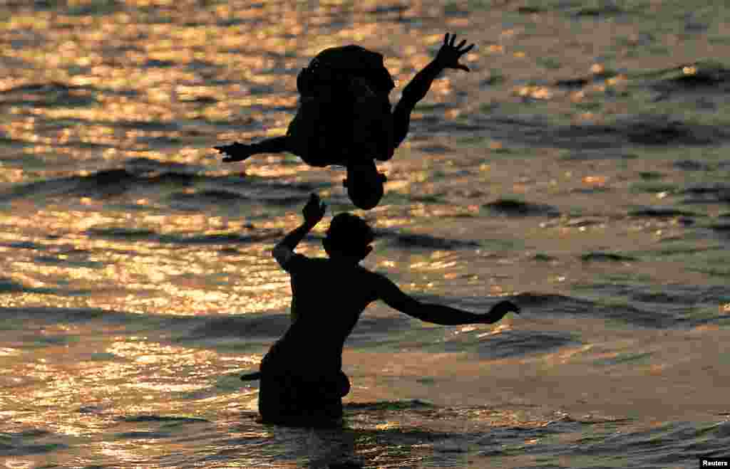 A boy is flipped into the sea by another in Colombo, Sri Lanka.