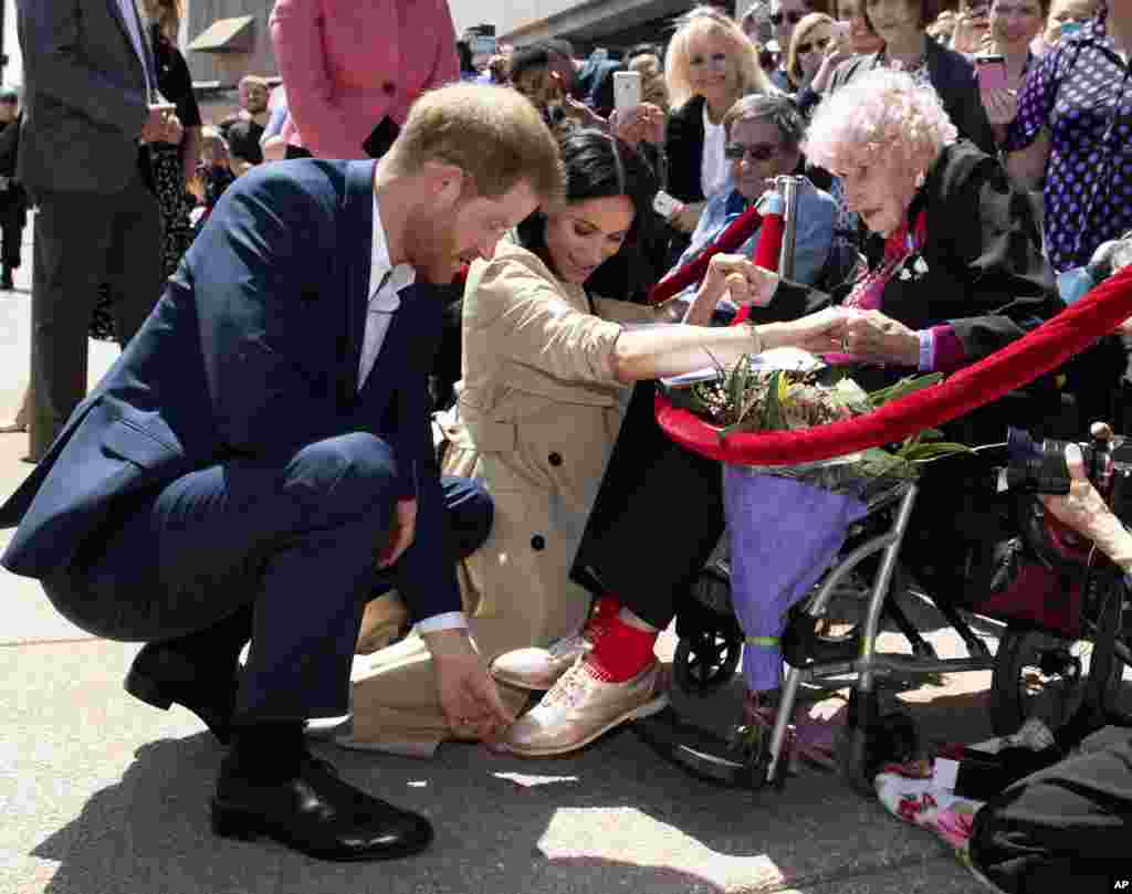 Britain's Prince Harry and Meghan, Duchess of Sussex, meet 98-year-old Daphne Dunne during a walkabout outside the Opera House in Sydney, Australia. Prince Harry and his wife Meghan are on a 16-day tour of Australia and the South Pacific.