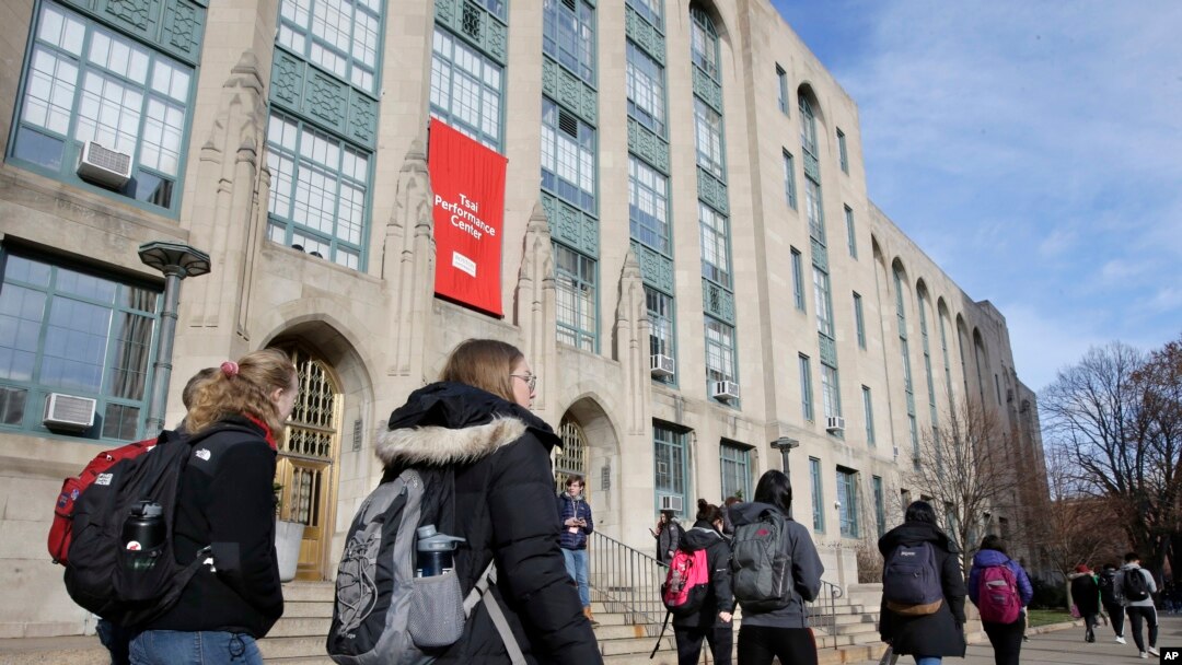 FILE - Students and passers-by walk past an entrance to Boston University College of Arts and Sciences, in Boston, Massachusetts, Nov. 29, 2018.