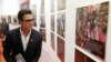 FILE - Actor Brad Pitt looks at photographs at a fringe event of a summit to end sexual violence in conflict in London.