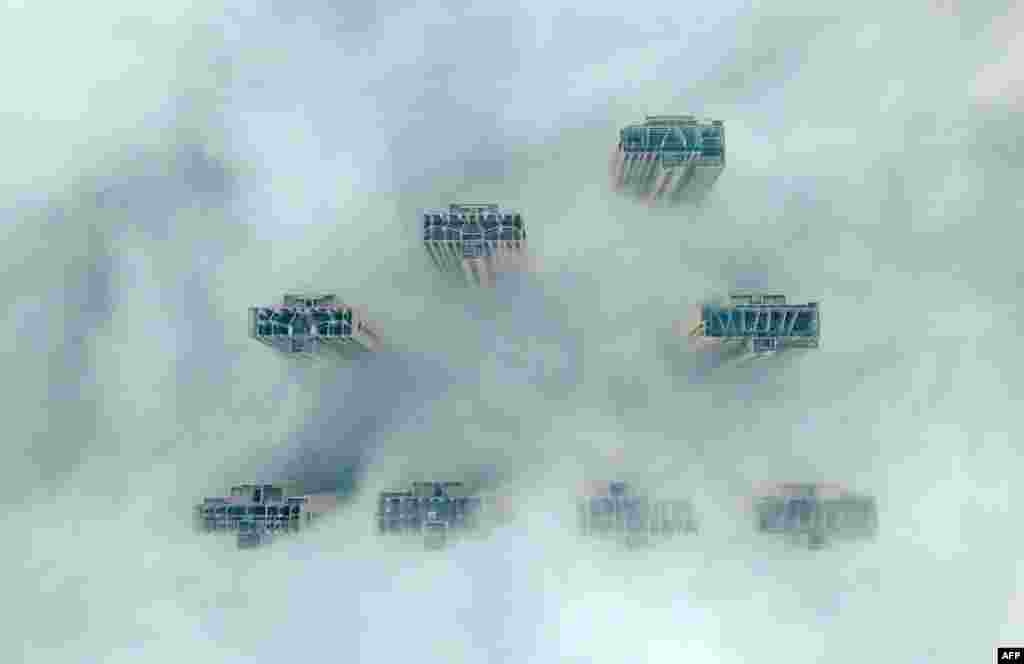 This aerial view shows the tops of high-rise buildings poking out from heavy fog in Yangzhou, in China's eastern Jiangsu province.