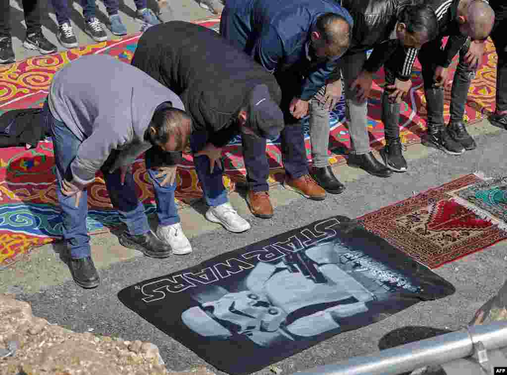 Palestinian Muslim men perform the Friday noon prayer in a street in Jerusalem's east neighborhood of Sheikh Jarrah.