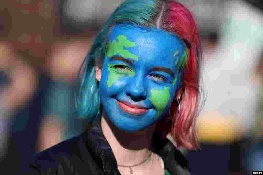 A girl looks on as people take part in a 'youth strike for climate change' demonstration in London, Britain.