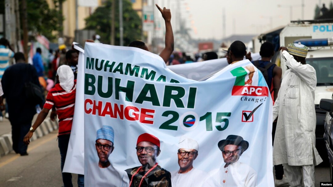 All Progressives Congress (APC) supporters hold a banner with a photograph of former military ruler Muhammadu Buhari in Lagos, Nigeria, Dec. 10, 2014.