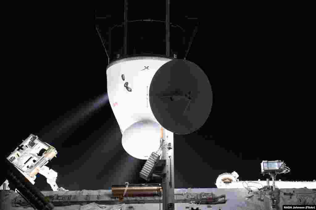 Plumes are pictured from the SpaceX Cargo Dragon resupply ship's Draco engines as they fire following its undocking from the International Space Station's Harmony module's space-facing port.