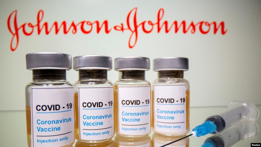 FILE - Vials with a sticker reading, "COVID-19 / Coronavirus vaccine / Injection only" and a medical syringe are seen in front of a displayed Johnson & Johnson logo in this illustration taken Oct. 31, 2020.