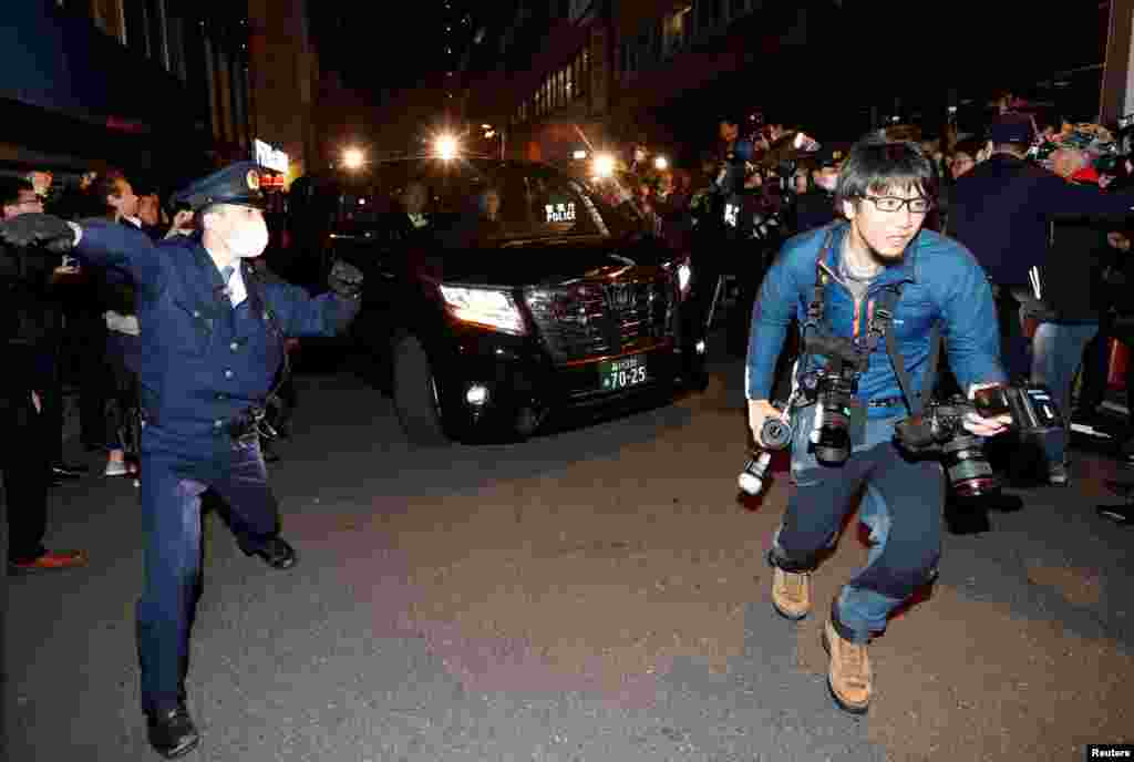 A car carrying former Nissan Motor Chairman Carlos Ghosn is surrounded by journalists as it leaves Ghosn's lawyer's office, in Tokyo, Japan.