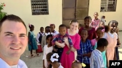 Nesta imagem, os missionários norte-americanos Davy e Natalie Lloyd, que foram mortos no Haiti em 23 de maio de 2024, posando com crianças haitianas