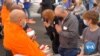 Participants pray as they offer food to Buddhist monks in a demonstrated workshop for a group of the AFS exchange students and volunteers during the AFS Thai Town Tour, a day-long tour of Thai Town hosted by the Thai Town Council Of Los Angeles, CA. 