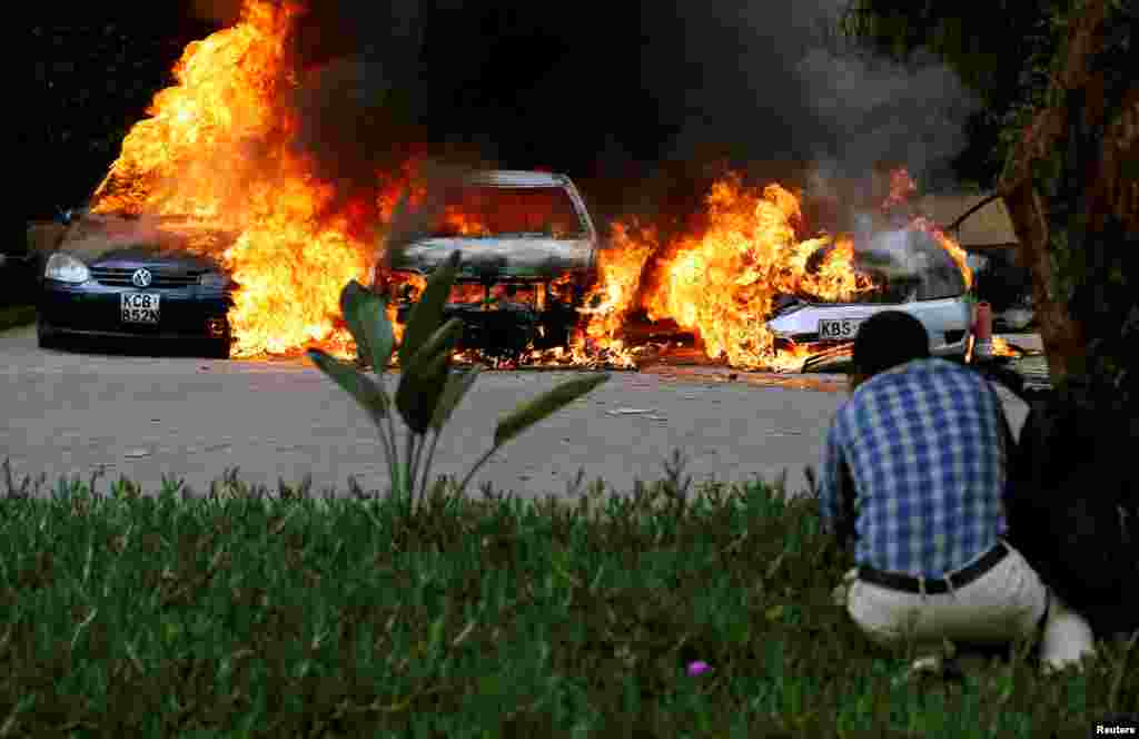Cars set on fire burn at the scene of explosions and gunshots in Nairobi, Kenya. Gunmen blasted their way into an upscale hotel and office complex in the capital, killing at least five people and sending workers diving under desks from an attack claimed by Somali Islamists al-Shabab.