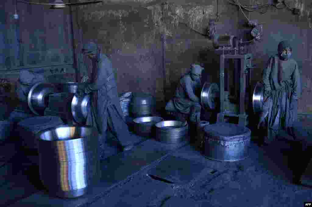 Afghan laborers polish metal pots at an aluminum factory in Herat.