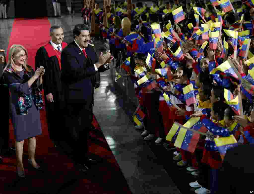 Venezuela's President Nicolas Maduro and first lady Cilia Flores stop to greet flag-waving children upon arrival to the Supreme Court for Maduro's inauguration ceremony in Caracas.
