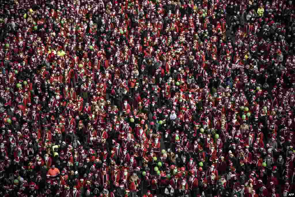 People dressed as Santa Claus take part in the 9th edition of the Santa Claus 'Papa Noel' rally on in Turin, Italy.