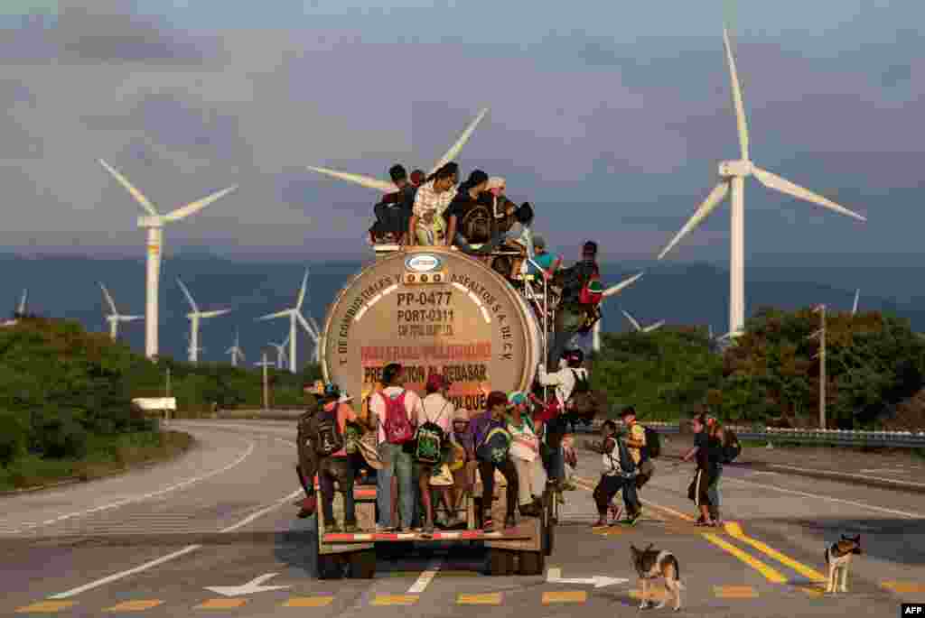 A truck, carrying mostly Honduran migrants taking part in a caravan heading to the U.S., passes by a wind farm on the way to Juchitan, near the town of La Blanca in Oaxaca State, Mexico.